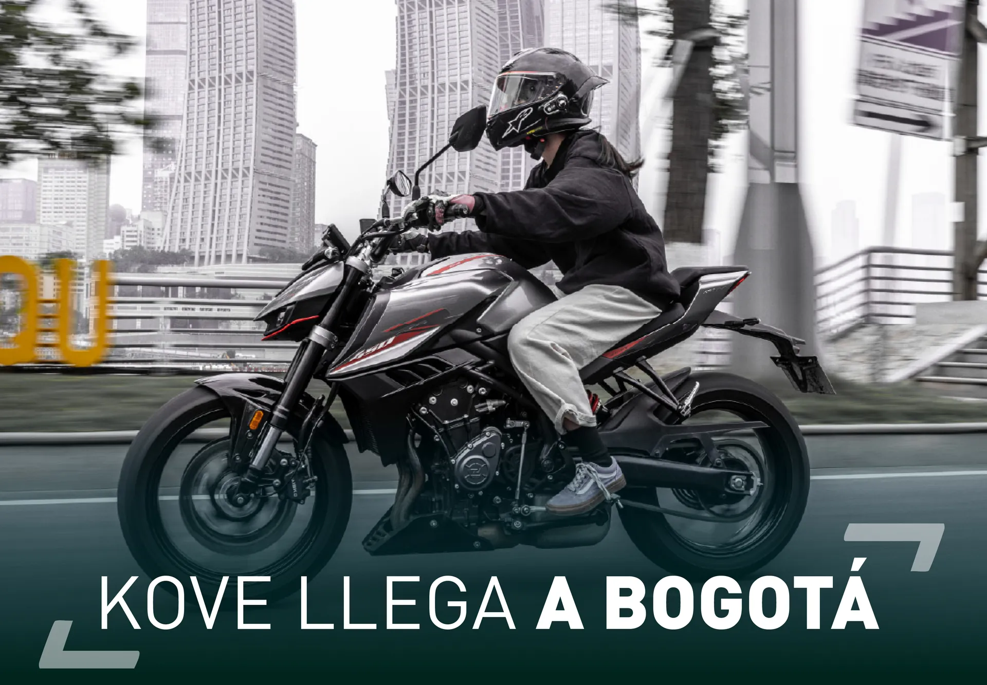Motociclista con casco integral circulando en una KOVE naked por una avenida, con rascacielos al fondo, y el titular «KOVE llega a Bogotá» sobre la imagen