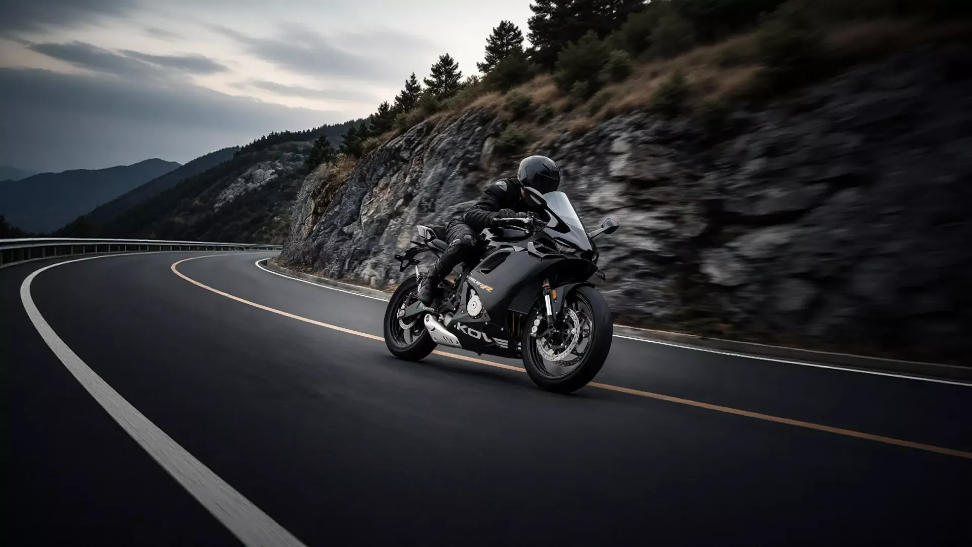 Una KOVE 450 RR negra inclinada en una curva de carretera de montaña.